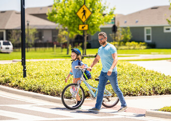 father and son on bicycle at fathers day. active father setting a example for fathers son. fathers parenting with son outdoor. childhood of son supported by fathers care. learning moments
