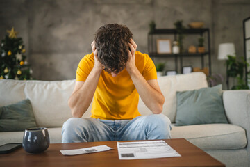adult young man worried exhausted about expensive bills at home