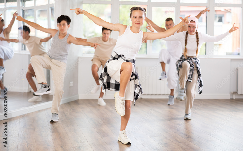 Wall mural teenage girl rehearsing hip hop dance in group in dance studio