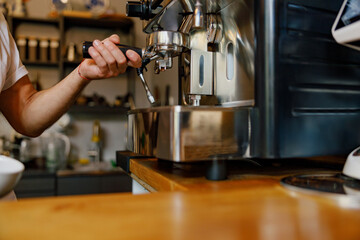 A skilled barista working with an espresso machine, showcasing culinary expertise in a cozy caf