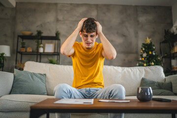 adult young man worried exhausted about expensive bills at home