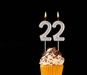 Birthday cupcake on black background - Number 22 shaped candles.