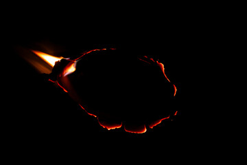 burning paper, glowing edge of paper on a black background