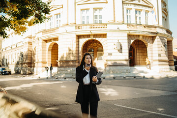 Young businesswoman sending voice message on smartphone on the street	