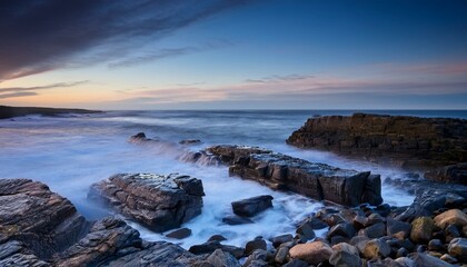 Obraz premium twilight over the rocky shores of ssoda den near howick northumberland