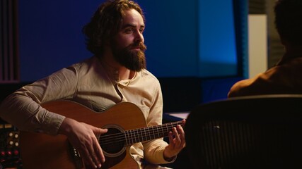 Skilled composer producing and recording new track on guitar, creating a live performance in...