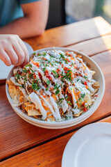 Gourmet carnitas nachos at outdoor restaurant