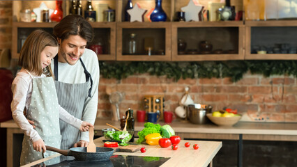 Dad teaching his cute daughter how to cook food on pan, preparring healthy lunch together, free space