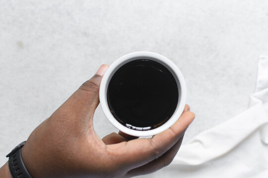 Overhead view of dark molasses in a white bowl, top view of blackstrap molasses