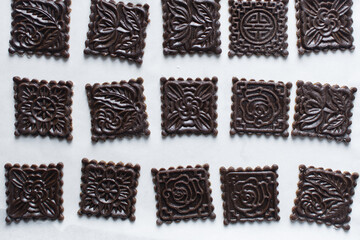 top view of stamped gingerbread cookie dough, Overhead view of cut out molasses cookie dough on a marble countertop, process of making christmas cookies