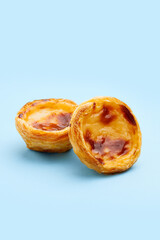Traditional Portuguese egg tart dessert Pasteis Pastel de nata or Pasteis de Belem on blue...