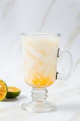 Es Kelapa Jeruk, a typical Indonesian drink made from fresh oranges squeezed with grated young coconut. with copy space. perfect for recipe, article, catalogue, or any commercial purposes.