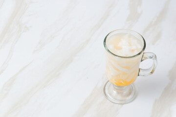 Es Kelapa Jeruk, a typical Indonesian drink made from fresh oranges squeezed with grated young coconut. with copy space. perfect for recipe, article, catalogue, or any commercial purposes.