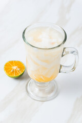 Es Kelapa Jeruk, a typical Indonesian drink made from fresh oranges squeezed with grated young coconut. with copy space. perfect for recipe, article, catalogue, or any commercial purposes.