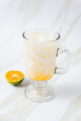 Es Kelapa Jeruk, a typical Indonesian drink made from fresh oranges squeezed with grated young coconut. with copy space. perfect for recipe, article, catalogue, or any commercial purposes.