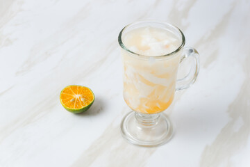 Es Kelapa Jeruk, a typical Indonesian drink made from fresh oranges squeezed with grated young coconut. with copy space. perfect for recipe, article, catalogue, or any commercial purposes.