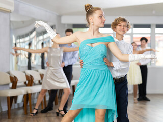Happy girls paired with guys dance salsa in dance class