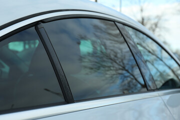 Modern car with tinting foil on window outdoors, closeup