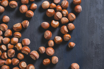 Raw hazelnuts in a stone mortar against a dark background
