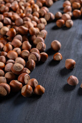 Raw hazelnuts in a stone mortar against a dark background