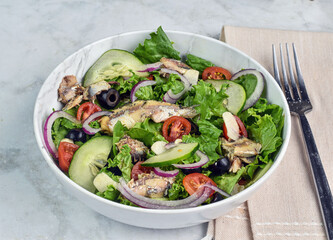 garden salad  with sardines on top