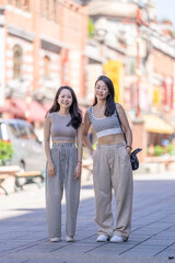 Two Taiwanese women in their 30s wearing casual outfits walk along Dihua Street in Taipei City, Taiwan, in September.