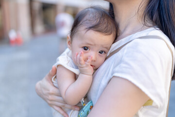 A 6-month-old baby held by a woman in her 30s inside a building near Dihua Street in Taipei City, Taiwan, in September.