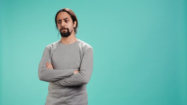 Grumpy man crossing arms, feeling upset by events, isolated over studio background. Portrait of stressed moody person shaking head, left speechless by troubling news, camera B