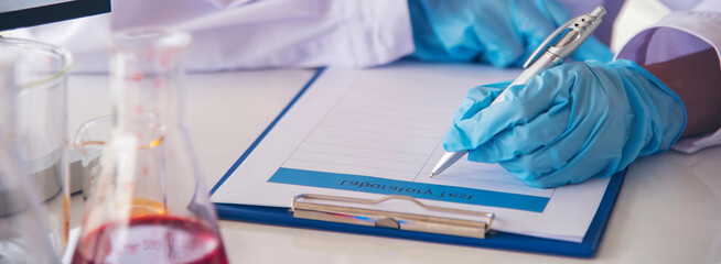 Banner Asian woman scientist hand write note research in medical lab look at science microscope. Panorama biology chemistry lab. Asian Female technician laboratory using microscope with copy space