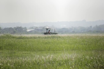 Someone was operating a lawn mowing tractor in a large field.