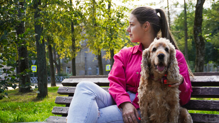 dog walking services. female owner with a cocker spaniel in the park. spending time together.