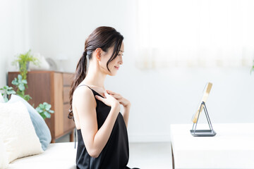デコルテを触るワンピースを着た女性