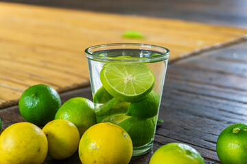 A glass of refreshing lemon water with fresh lemon slices on a wooden table.
