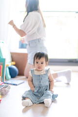 A 1 year old Taiwanese girl spending time playing happily with her parents, a man and woman in their 20s, in a room of a high rise apartment in Taichung City, Taiwan.