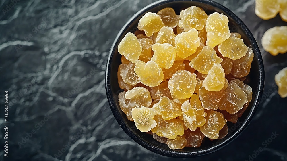 Aufkleber candied ginger in black bowl on dark stone background top view copy space : generative ai
