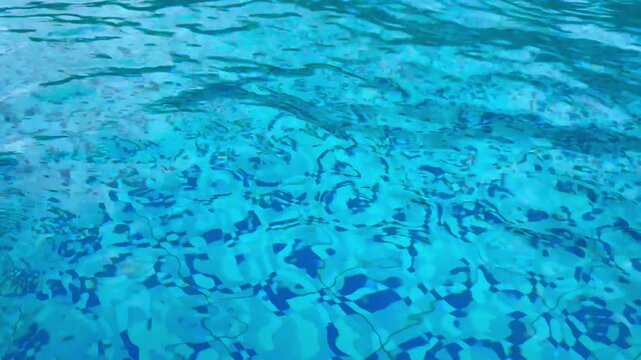 The surface of the swimming pool water is wavy and so clear that you can see the bottom of the pool