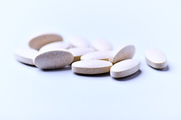 Ashwagandha (Withania somnifera) tablets. Concept for a healthy dietary supplementation. Bright paper background. Close up. Copy space.	