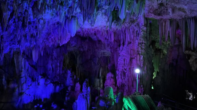 A mesmerizing display of stalactites and stalagmites bathed in vibrant colors located in Pacitan, Indonesia