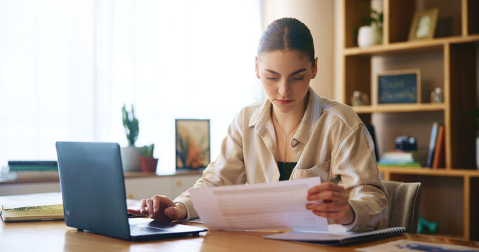 Woman, reading and document with laptop at house for loan approval, bank application and budget planning. Girl, online taxes and review paperwork for mortgage, financial invoice and investment letter