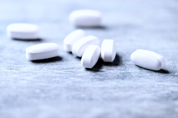 Amino acids tablets. Nutrition for bodybuilding. Fitness supplements on bright wooden background. Soft focus. Copy space.