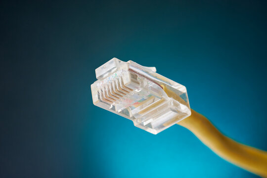 close-up of rj-45 ethernet networking jack connector isolated blue background, used to connect computers, routers and other devices over wired local area network