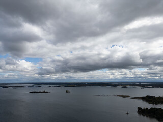 Tranquil aerial view of the 1000 Islands region, showcasing scattered islands on serene waters under a vast sky, capturing natural beauty and peacefulness.