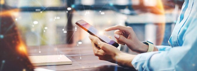 Close-up photo of female hands with smartphone. Concept of networking or remote work. Global...