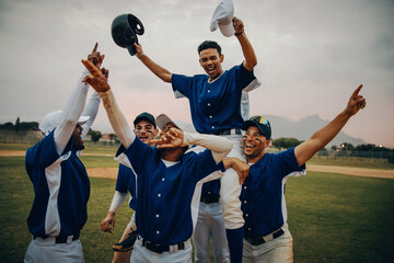 Baseball team celebrating victory on the field, lifting player in a triumphant success