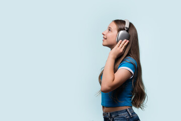 Young girl with headphones, listening to music and smiling.