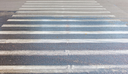 Fototapeta premium A crosswalk with white lines on a wet road