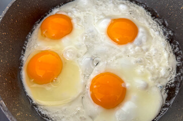 A pan of eggs is cooking on a stove