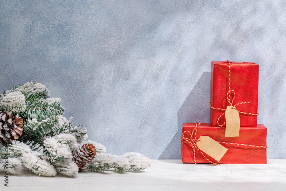 Aufkleber christmas template featuring gift boxes and snowy fir tree branches on a table with shadows and sun 
