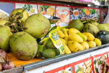 Fruit stall with colorful signs and posters selling exotic fresh fruit and fruit juice, coconuts, mango and street food, Fruit markets in Thailand