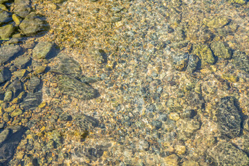 Clear Riverbed. Close up of a riverbed showing clear water flowing over smooth stones and pebbles. 